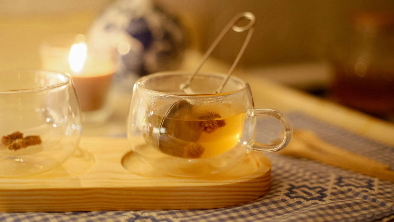 Cup of herbal tea beside a lit candle in the evening