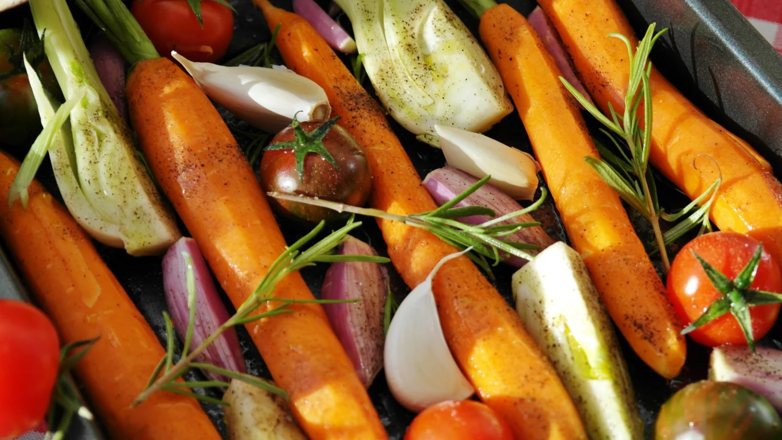 Carrots, tomatoes and herbs ready for roasting