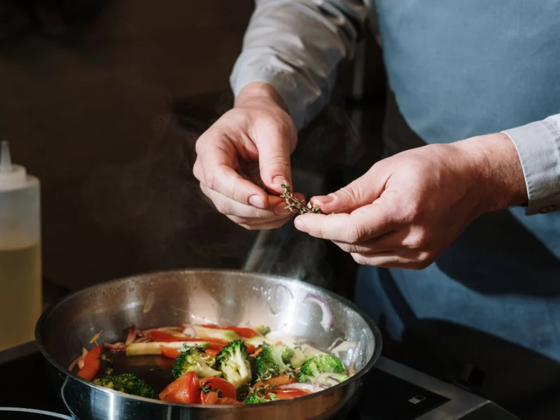Vegetable stir-fry being seasoned in a pan