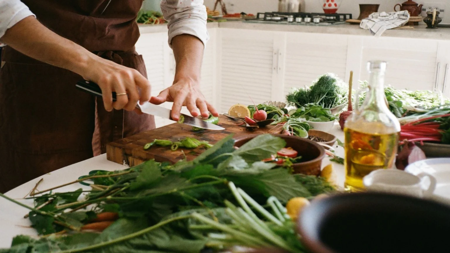 Person preparing a fresh vegetable salad in a home kitchen